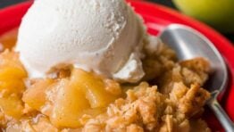 Apple crisp served on plate with ice cream