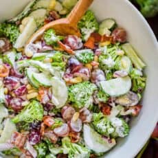 Finished broccoli grape salad in a serving bowl with mixing spoon