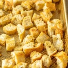 Homemade croutons on a metal baking sheet.