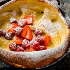 Dutch baby topped with fruit and powdered sugar