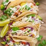 Our go-to fish tacos recipe for entertaining! Easy, excellent fish tacos with the best fish taco sauce; an irresistible lime crema! | natashaskitchen.com