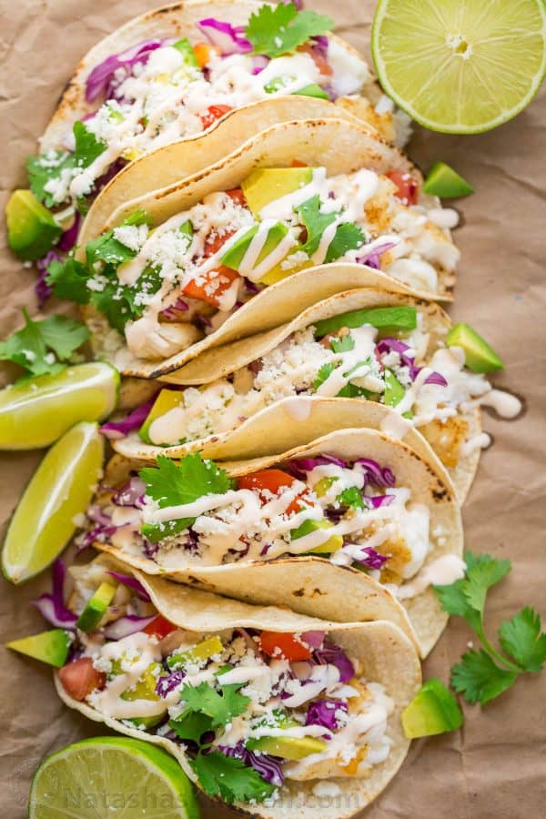 Our go-to fish tacos recipe for entertaining! Easy, excellent fish tacos with the best fish taco sauce; an irresistible lime crema! | natashaskitchen.com