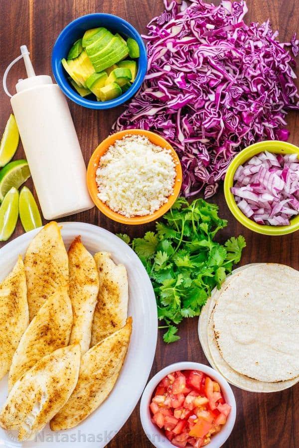 Our go-to fish tacos recipe for entertaining! Easy, excellent fish tacos with the best fish taco sauce; an irresistible lime crema! | natashaskitchen.com