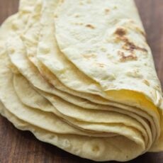 A stack of homemade flour tortillas folded in half.