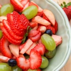 A bowl of fruit salad with citrus and honey syrup