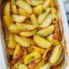 Sliced potato wedges in casserole dish garnished with oregano