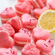 Heart Macarons are easier than you think! Heart-shaped macarons with tangy-sweet lemon buttercream. Includes video tutorial + free printable heart template! | natashaskitchen.com