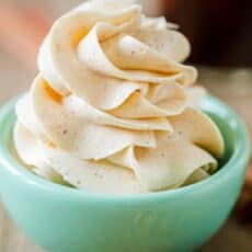 Honey butter in a blue bowl with honey stick