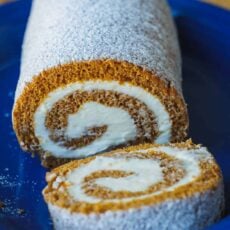 Pumpkin Roll Cake with powdered sugar and a slice