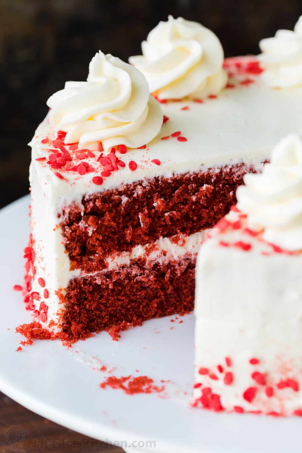 Red Velvet Cake cake on platter with one piece removed