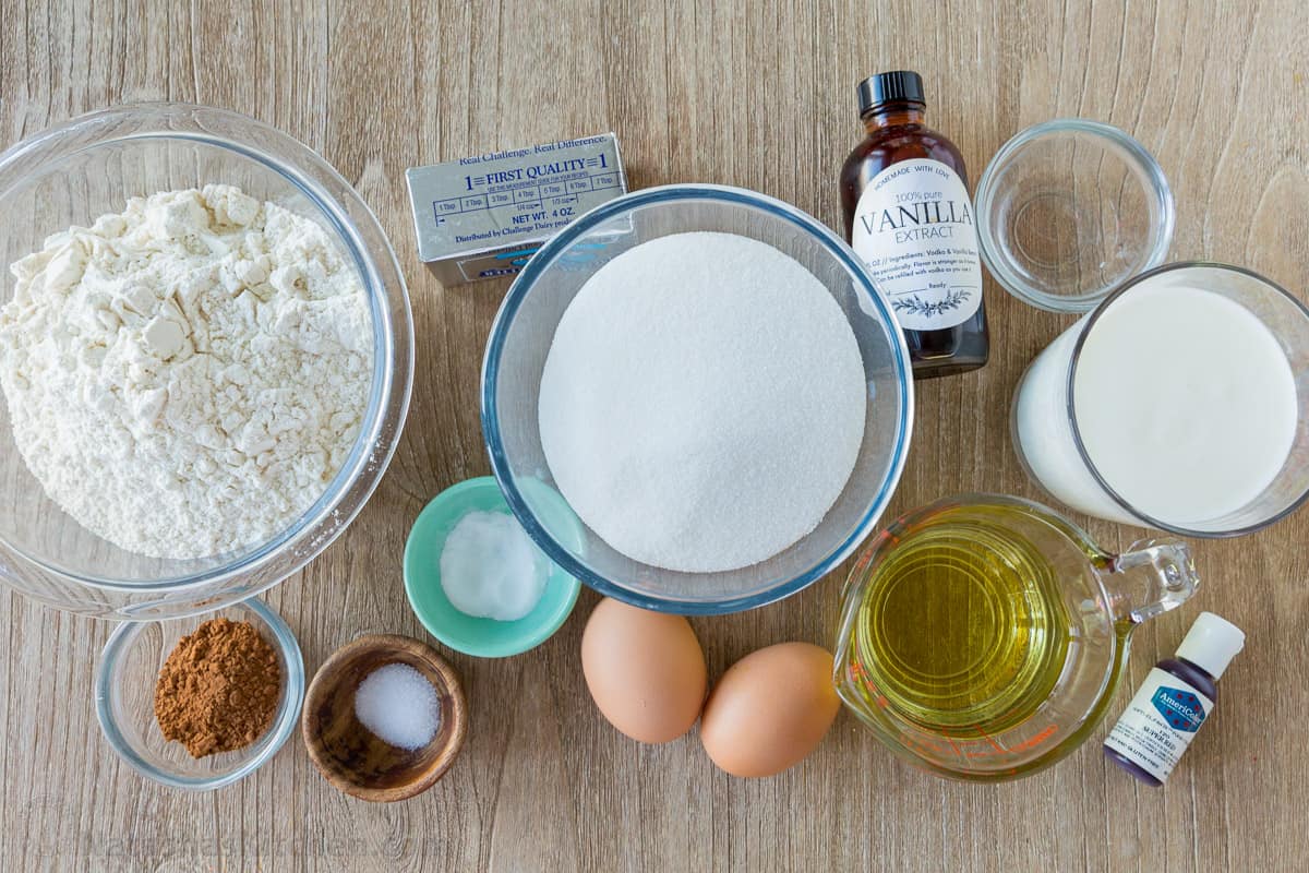 Ingredients for red velvet cake with cocoa, flour, sugar, eggs, oil, butter, buttermilk, vinegar, baking soda