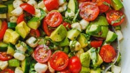 tomato cucumber mozzarella salad in a bowl with a spoon