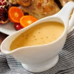 Turkey gravy in gravy boat with turkey in background