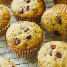 golden zucchini muffins cooling on a rack